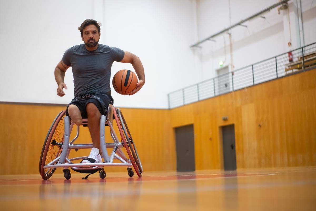 Home en cadira de rodes jugant a bàsquest