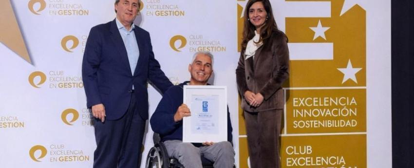 Albert Carbonell, president d'ECOM, recollint a l'escenari el Segell EFQM 400, acompanyat per dues persones representants del Club de Excelencia en Gestión. 