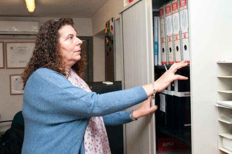 Mujer con discapacidad trabajando en una oficina, ante unos archivos