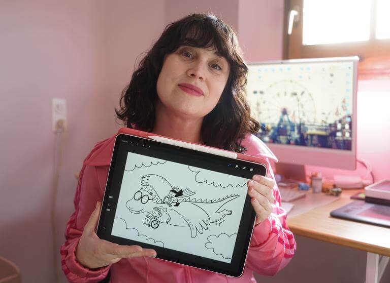 L'artista Lyona exposant el dibuix que ha fet