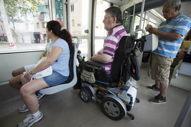una persona usuària de cadira de rodes viatjant dins el tramvia